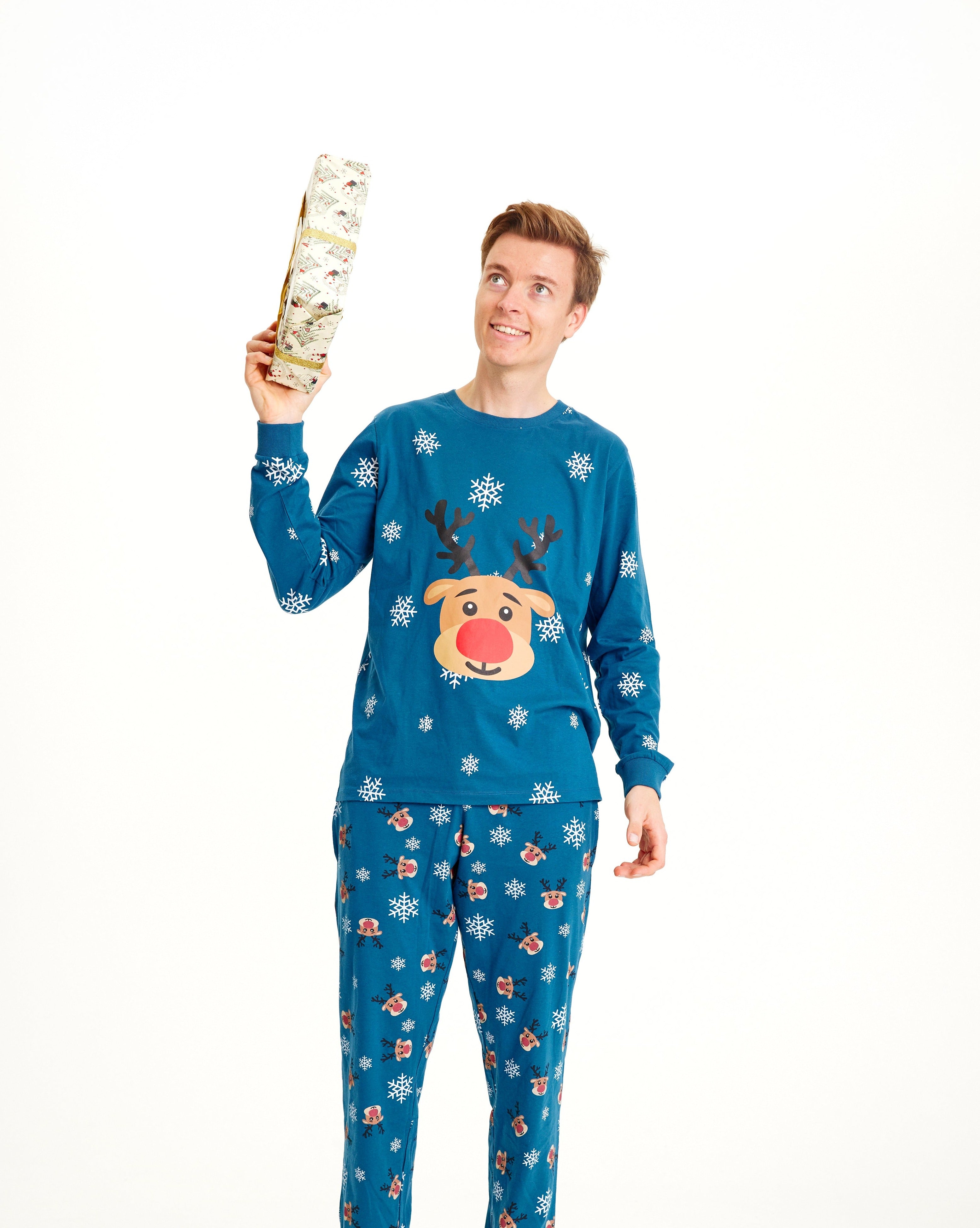 Ein Mann trägt einen blauen Weihnachtspyjama mit Rudolph darauf.